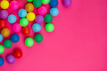 Abstract colored balls background. Multi-colored taw toy scattered on bright paper. Base for design nice backdrop, wallpaper, poster. Noisy surface texture