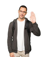 Serious student making a gesture of stop with his palm