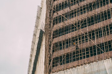 Closeup of bamboo scaffolding on the skyscraper with sky in the background