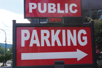 Red public parking sign with arrow