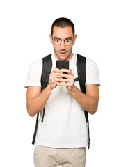 Shocked student using a mobile phone