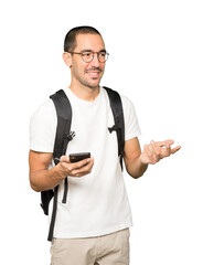 Happy student using his mobile phone