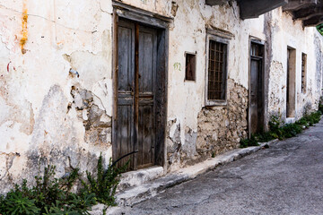 Fototapeta na wymiar Narrow and colorful street in the village of Kritsa in the island of Crete. White street, beautiful traditional housing in Greece. 