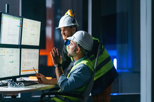 Group of operators control process on product line uses industry 4.0 and digital technology on modern factory. Two engineers follow assembly process uses SCADA system which AI technology and UI