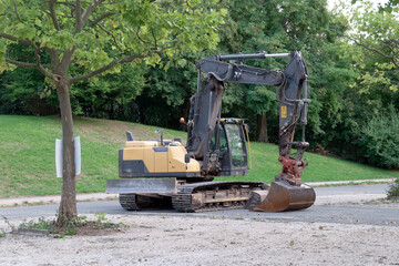 Fototapeta na wymiar Single excavator stands in a park