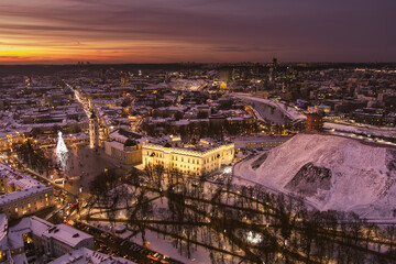 Beautiful Vilnius city panorama in winter with snow covered houses, churches and streets. Aerial evening view. Winter city scenery in Lithuania.