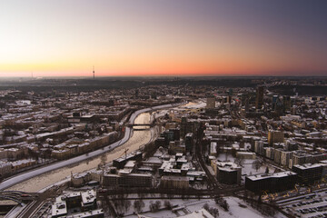 Beautiful Vilnius city panorama in winter with snow covered houses, churches and streets. Aerial sunset view. Winter city scenery in Lithuania.