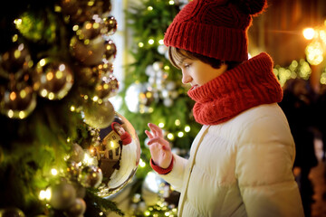 Cute young girl admiring Christmas lights and decorations on the streets of Vilnius, Lithuania....