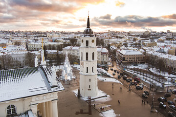 Obraz premium Aerial Vilnius city panorama in winter with snow covered houses, churches and streets. Cathedral square and Christmas tree. Winter city scenery in Lithuania.