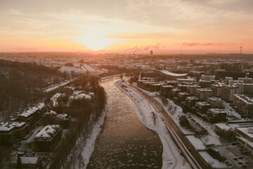 Beautiful Vilnius city panorama in winter with snow covered houses, churches and streets. Aerial evening view. Winter city scenery in Lithuania.