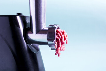 Kitchen appliance electric meat grinder on a light background. Meat grinder processes meat into...