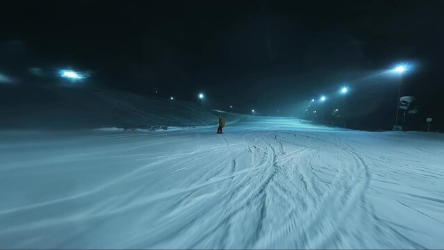 Night snowboarding in the snow. Skiing on the night ski slope. Night shooting it snows. Shooting on the move. Wide angle go pro