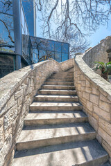 Outdoor staircase with sunlit concrete steps and stone railings on a sunny day