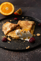 Crepes stuffed with orange marmalade with shortbread ice cream and powdered sugar