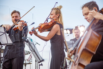 Musicians playing classical instrumental music on outdoor stage