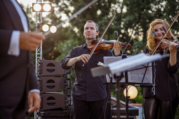 Violin players playing in orchestra on the street