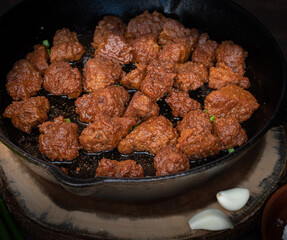 Cast iron fried seitan on wooden table