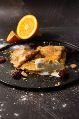 Crepes stuffed with orange marmalade with shortbread ice cream and powdered sugar