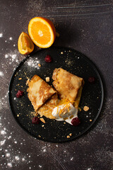 Crepes stuffed with orange marmalade with shortbread ice cream and powdered sugar