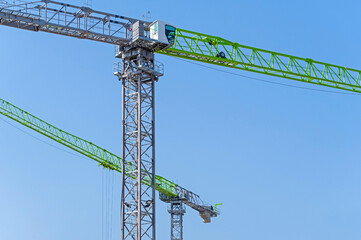 Fototapeta na wymiar Freestanding tower cranes on a building site