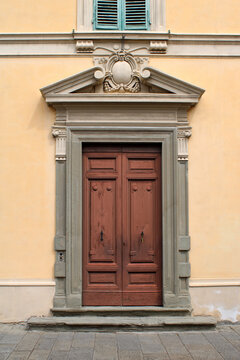 Portale antico con porta in legno frontone lesene e protome