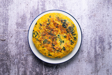 Spinach and potato omelette. Traditional Spanish tortilla recipe. Top view shot.