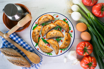 Argentine empanadas handmade with traditional recipe. Aerial shot decorated with red pepper and arugula.