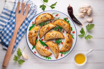 Argentine empanadas handmade with traditional recipe. Aerial shot decorated with red pepper and arugula.