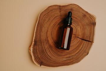 Serum jar on wooden natural slice, product placement - obrazy, fototapety, plakaty