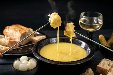 Swiss cheese fondue with bread, pickles and wine, the festive dinner is often served at new year,...