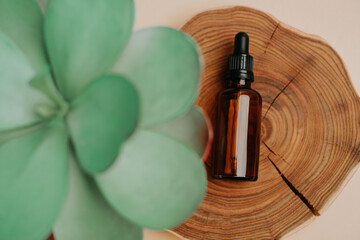 Serum jar on wooden background and plant leaf