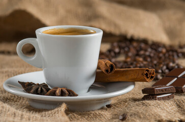 Fototapeta na wymiar Espresso and chocolate slices on a brown background of burlap