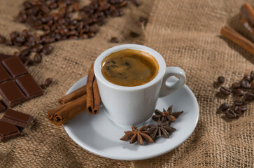 Espresso and chocolate slices on a brown background of burlap