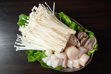 Variou mushroom and raw scallops on plates prepare for steamboat dinner
