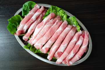 Raw pork slices on steel plate ready for shabu-shabu (steamboat)