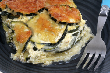 Gratin de courgettes dans une assiette avec une fourchette en gros plan