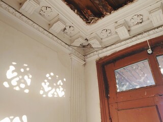 A hallway or entrance of a 19 century house. Old door and interior with Stucco molding and...