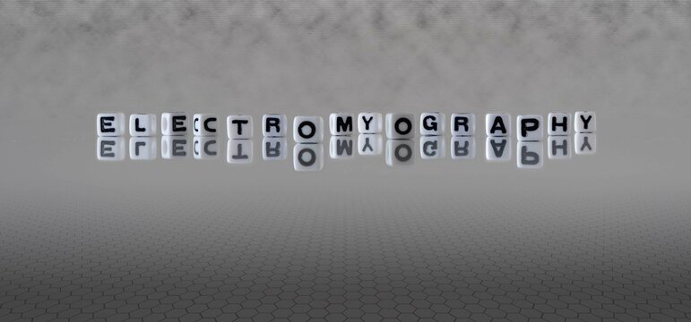electromyography word or concept represented by black and white letter cubes on a grey horizon background stretching to infinity