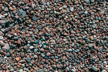 Small smooth stones close-up, small debris among the stones, horizontal background.