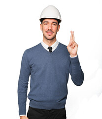 Young architect making a fingers crossed gesture