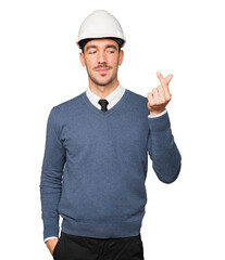 Happy young architect making a money gesture with his hand