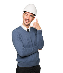 Young architect making a gesture of calling with his hand