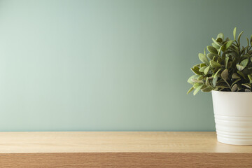 Empty wooden table with home plant decor over green wall background.  Modern interior mock up for...