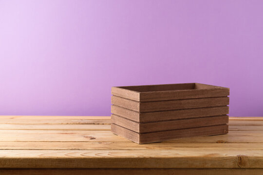 Brown wooden box on table over purple wall background. Autumn harvest concept for mock up design