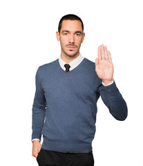 Serious young man making a gesture of stop with his palm