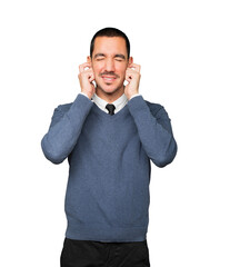 Young man worried about loud noises and covering his ears