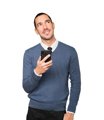 Happy young man looking up and using a mobile phone