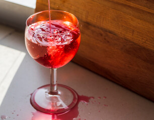 Shot of a red liquid being poured in to the wine glass. Concept