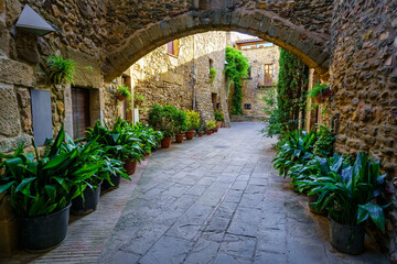 Passageways with stone arcade and medieval houses in a picturesque style and of great beauty, Monells, Girona, Catalonia.