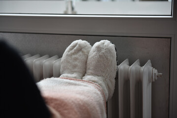 Feet in warm shoes on a warm heater